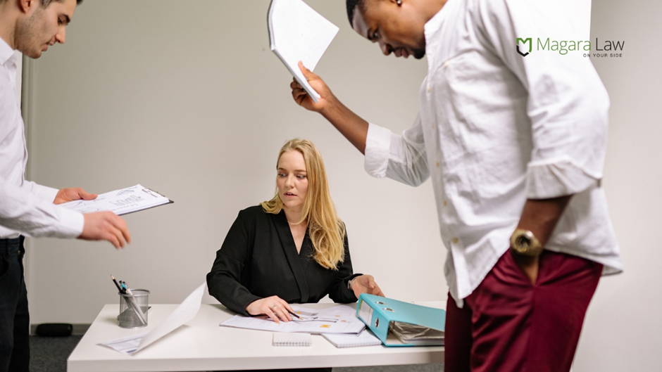 A woman having piles of work dumped on her desk amid unwanted harassment.